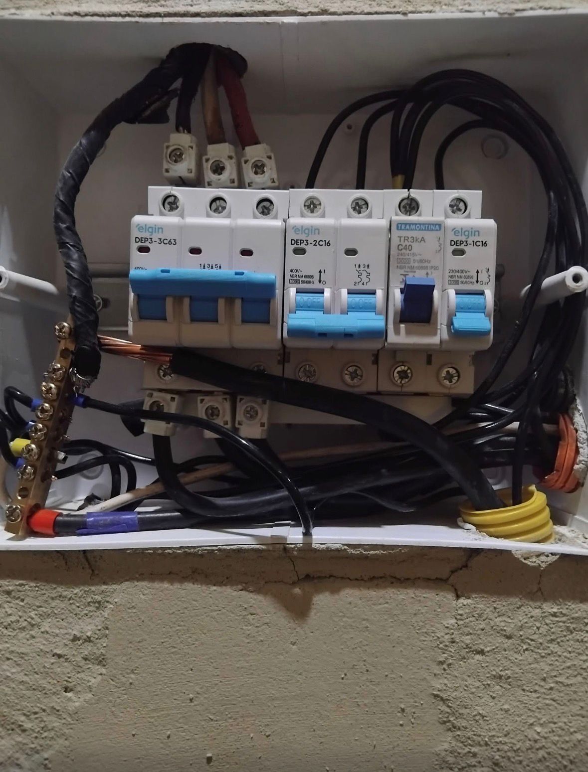 Quadro elétrico com cabos desorganizados e improvisos